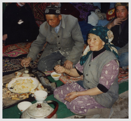 A family sitting around the eating cloth